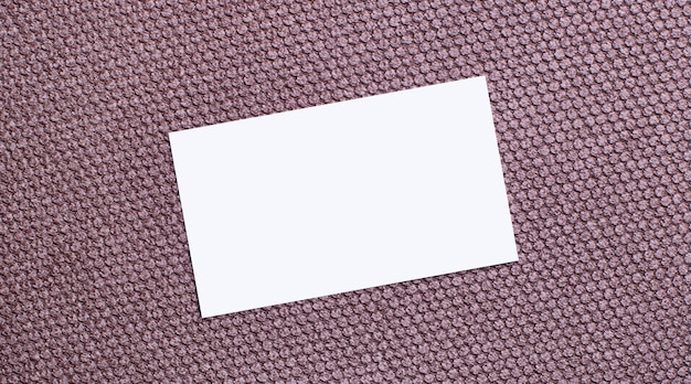 Sobre un fondo marrón, una tarjeta blanca rectangular en blanco con un lugar para insertar texto. Plantilla