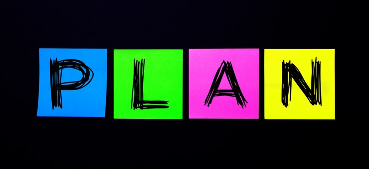 Foto sobre un fondo negro, pegatinas multicolores brillantes con la palabra plan