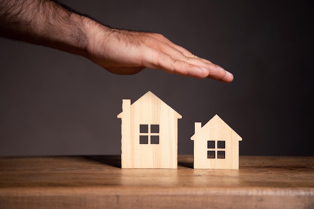 Sobre la mesa hay un modelo de casas de madera.