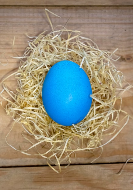 Sobre una mesa de madera huevos de Pascua manchados en un nido de paja Concepto de Pascua y religión