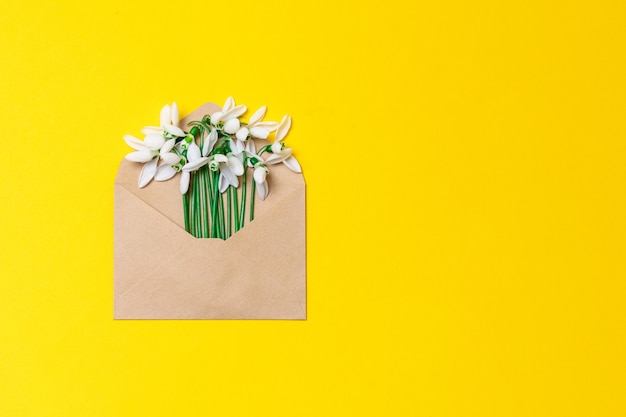 Sobre de papel artesanal abierto con flores de primavera