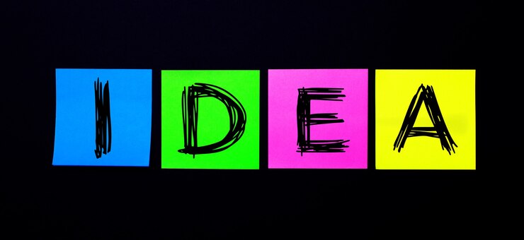 Foto sobre una pared negra, pegatinas multicolores brillantes con la palabra idea