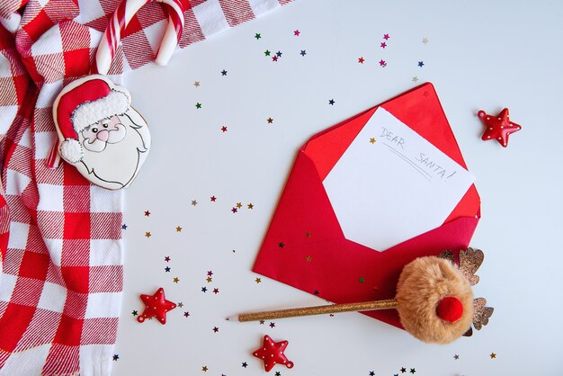 Foto sobre rojo con una carta a santa claus, una servilleta en una jaula y un bolígrafo