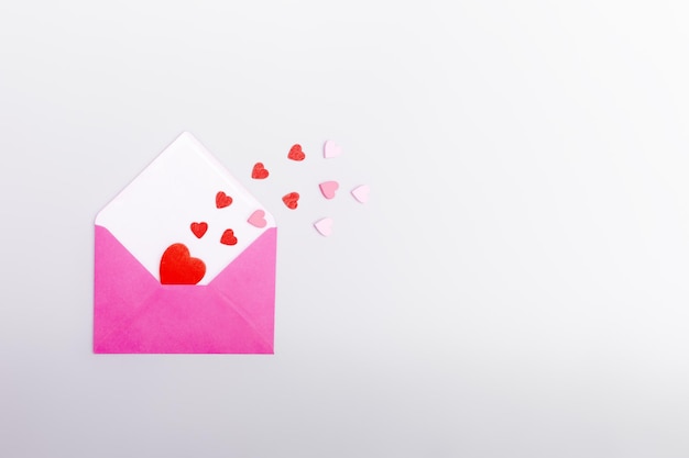 Sobre rosa y corazones sobre un fondo gris El concepto del día de San Valentín amor citas y bodas Símbolo de cartas de amor Copiar espacio plano