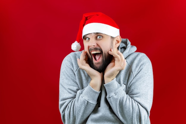 Sobre um fundo amarelo de Natal, um homem que segura brinquedos de Natal com bolas douradas nas mãos, ele sorri para a câmera e os levanta diante de si.