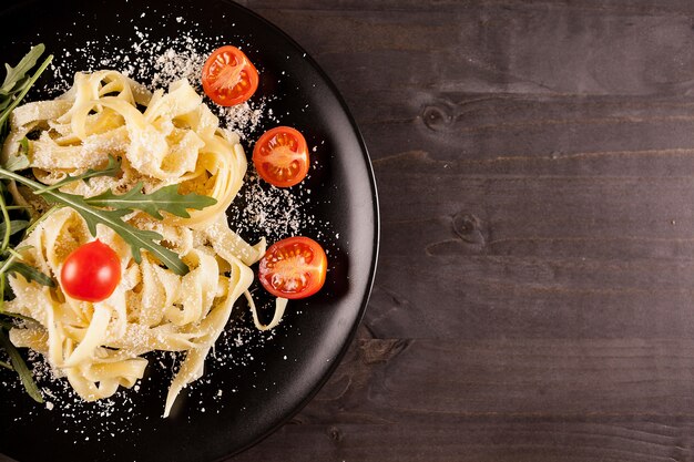 Sobre la vista superior de pasta tagliatelle sobre mesa de madera