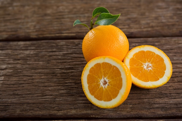 Sobrecarga de naranjas sobre mesa de madera