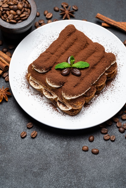 Sobremesa clássica de tiramisu na placa cerâmica em fundo de concreto