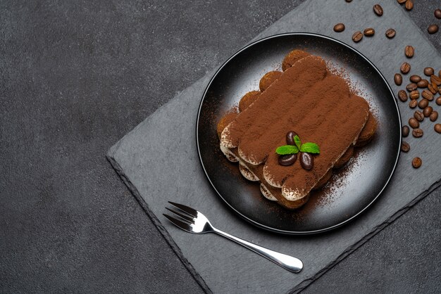 Sobremesa clássica de tiramisu na placa de cerâmica na superfície de concreto