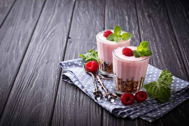 Sobremesa com granola, iogurte e framboesa. Foco seletivo