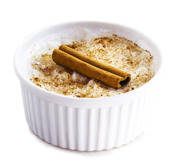 Sobremesa cremosa de pudim de arroz polvilhada e decorada com fundo branco de canela comida típica brasileira isolada