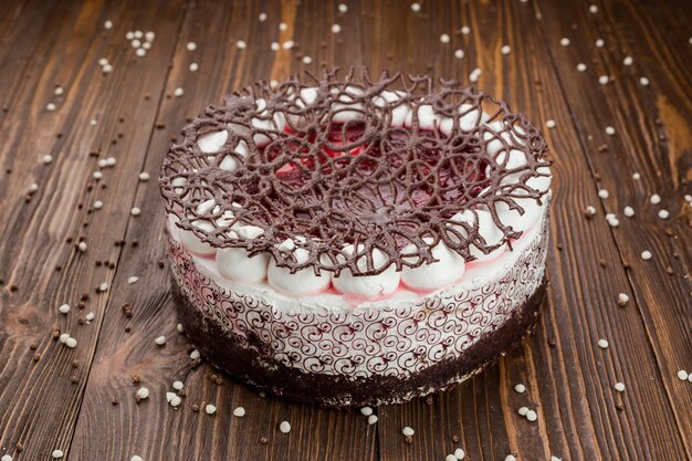 Sobremesa de bolo de morango com doces e chocolate em fundo de madeira