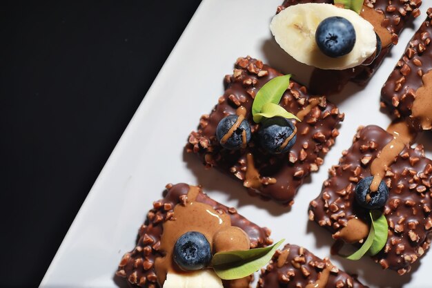 Sobremesa de chocolate com nozes e frutas frescas. lanche doce para biscoito de café em esmalte e migalhas de nozes com frutas.