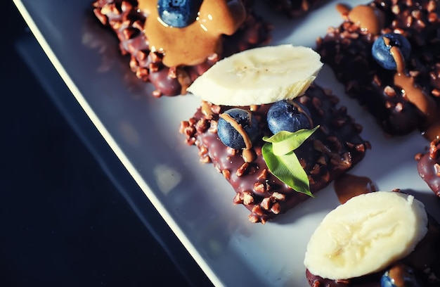 Sobremesa de chocolate com nozes e frutas frescas. lanche doce para biscoito de café em esmalte e migalhas de nozes com frutas.