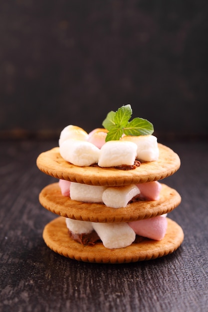 Sobremesa de cookies, chocolate e marshmallow sobre um fundo azul na decoração de Natal