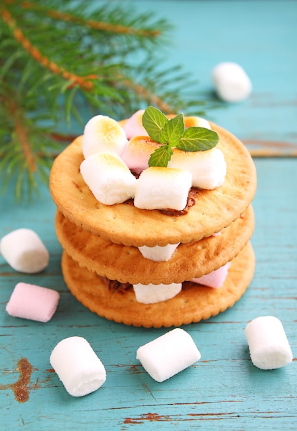 Sobremesa de cookies, chocolate e marshmallow sobre um fundo azul na decoração de Natal