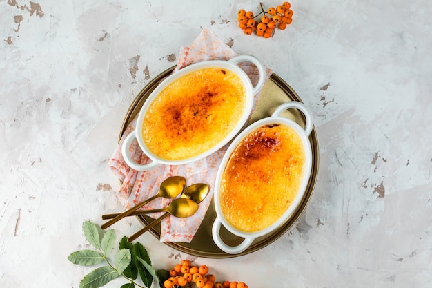 Sobremesa de creme brulee com creme em pratos brancos de cozimento, deliciosa sobremesa de outono.