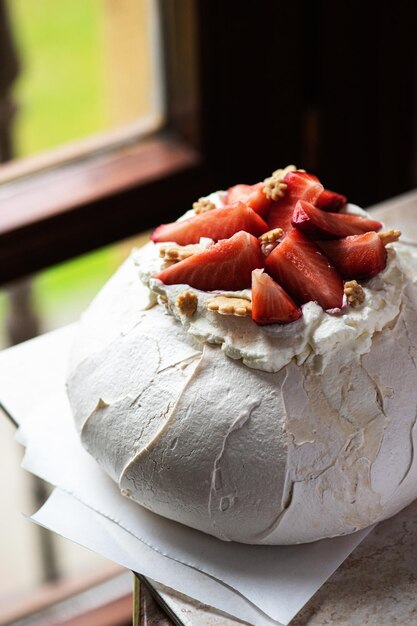 Sobremesa de frutas frescas de verão Pavlova perto da janela