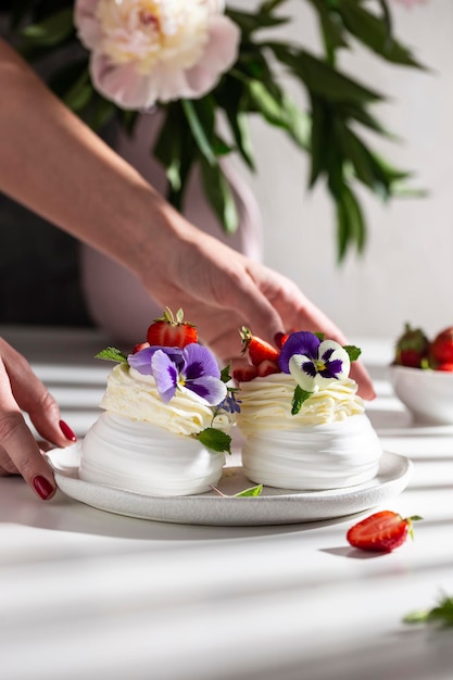 Foto sobremesa de pavlova doce decorada com morango fresco e flores