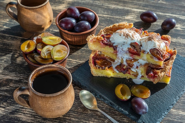 Sobremesa de torta de ameixa orgânica caseira pronta para comer torta de ameixa com sorvete e xícara de chá quente sobre o fundo de madeira