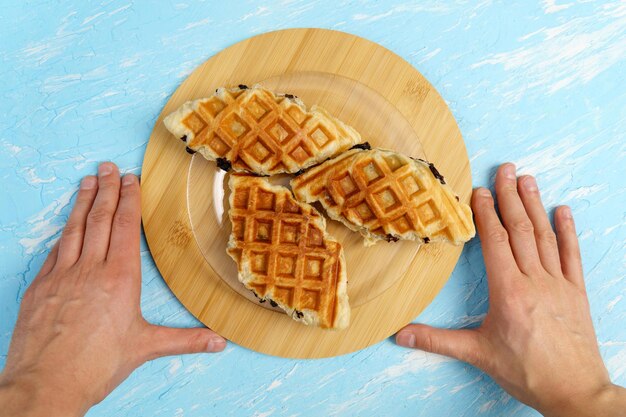 Foto sobremesa de waffle croffle ou croisant um casamento entre um croissant e um ferro de waffle topview fundo azul