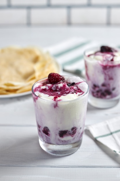 Sobremesa deliciosa com sorvete de baunilha e molho de frutas vermelhas e panquecas apetitosas