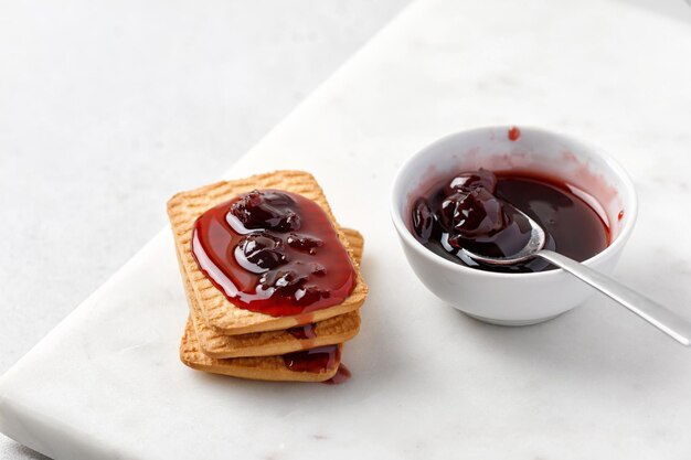 Sobremesa doce Biscoito e geléia Lanche doce Geléia de cereja Confiture Geléia vermelha pingando sobre biscoitos