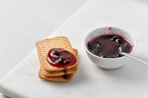 Sobremesa doce Biscoito e geléia Lanche doce Geléia de cereja Confiture Geléia vermelha pingando sobre biscoitos