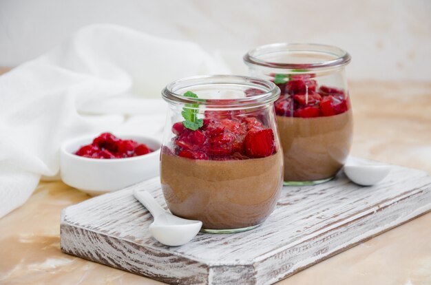 Sobremesa italiana. panna cotta de chocolate, mousse, creme ou pudim com molho de cereja em uma jarra de vidro