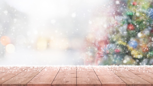 Foto sobremesa de madera vacía en la falta de definición con el fondo del árbol de navidad del bokeh.