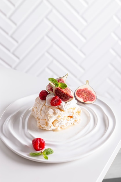 Sobremesa Pavlova, pedaço de pãozinho de merengue decorado com frutas vermelhas e figos