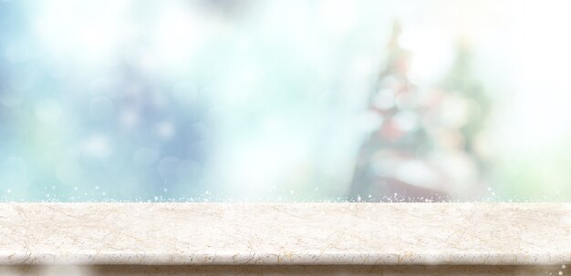 Sobremesa de piedra de mármol vacía con el árbol de navidad y la nieve abstractos de la falta de definición del bokeh