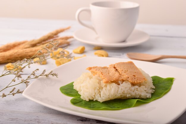 Sobremesa tailandesa ovo creme com arroz pegajoso na folha de bananeira