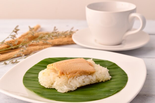 Sobremesa tailandesa ovo creme com arroz pegajoso na folha de bananeira