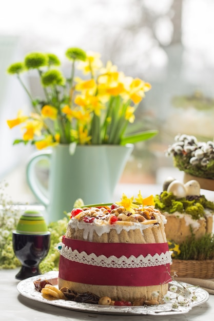 Foto sobremesa tradicional do requeijão da páscoa do russo, paskha ortodoxo na tabela com bolos do kulich, flores, ovos coloridos.