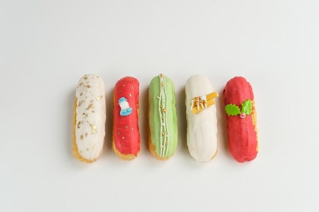 Sobremesa tradicional francesa. Éclairs doces e coloridos com cobertura de chocolate.