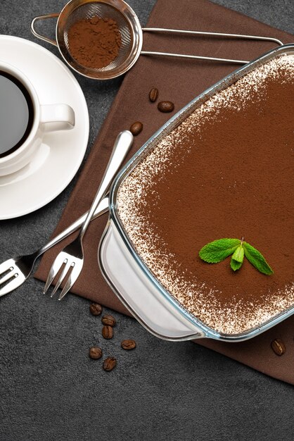 Foto sobremesa tradicional italiana tiramisu em assadeira de vidro e xícara de café expresso quente fresco