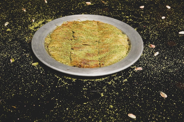 Foto sobremesa turca kunefe, kunafa, kadayif com pó de pistache e queijo quente comido um doce