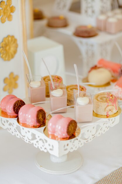 Sobremesas com frutas, mousse, biscoitos. Diferentes tipos de doces, pequenos bolos coloridos, macaron e outras sobremesas no buffet. barra de chocolate para o aniversário.