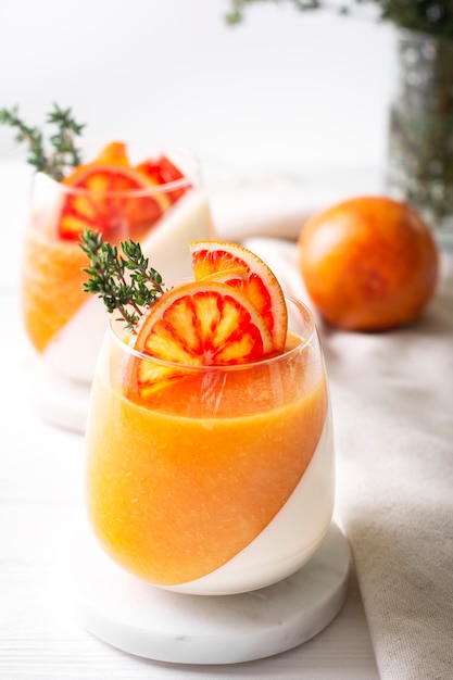 Foto sobremesas naturais panna cotta decoradas com laranjas e tomilho ficam em branco