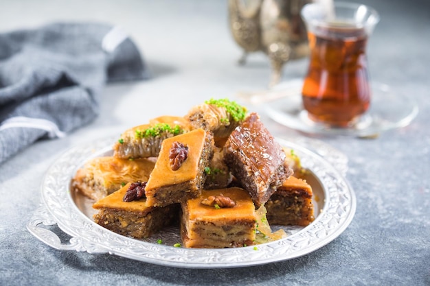 Sobremesas turcas tradicionais Baklava com chá. Baklava de mistura crocante em placa de prata.