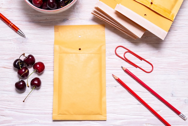 Sobres de burbujas en mesa de madera con cereza, concepto de verano