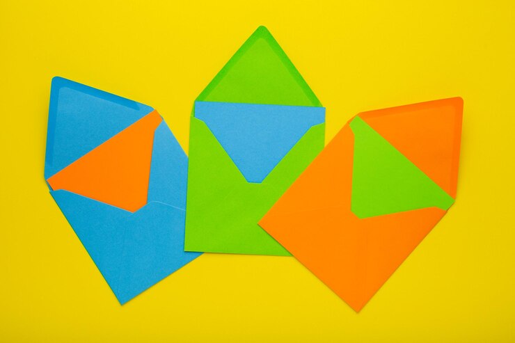 Foto sobres de colores sobre fondo amarillo como símbolo de recibir una invitación o felicitación