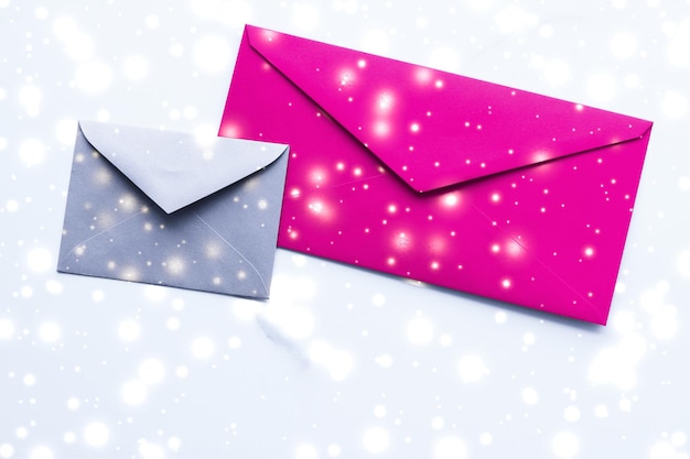 Sobres de papel en blanco de vacaciones de invierno en mármol con carta de amor de fondo plano de nieve brillante o diseño de tarjeta de correo de Navidad