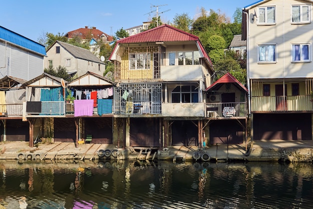 Sochy, Rusia - 14 de septiembre de 2020: habitaciones turísticas baratas alquiladas en chozas junto al río convertidas de garajes para botes