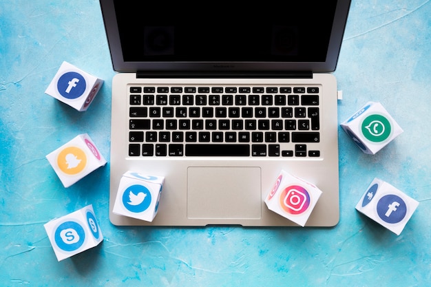 Social media-ikone blockiert auf laptop über dem blauen hintergrund