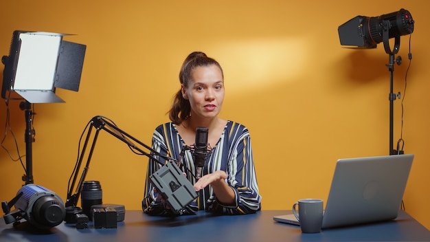 Foto social-media-star führt in ihrem studio eine professionelle überprüfung der v lock-batterie durch. professionelle überprüfung der videografie-ausrüstung durch den new-media-star-influencer des content-erstellers in den sozialen medien.