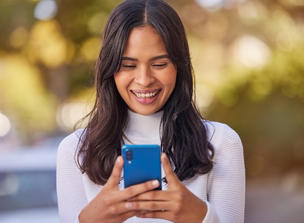 Social-Media-Telefon und Frau in der Stadt für geschäftliche Arbeiten und Lesen der Kommunikation auf einem Handy Fröhliches Lächeln und junges Mädchen, das auf einer mobilen App mit 5g-Technologie im Internet auf der Straße tippt