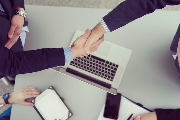 El socio comercial se da la mano en la reunión en la vista superior del edificio de oficinas moderno