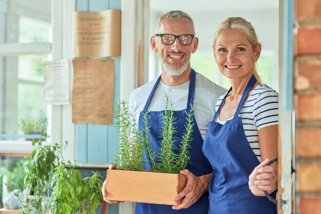 Socios caucásicos de mediana edad de pie en la puerta de la casa jardín